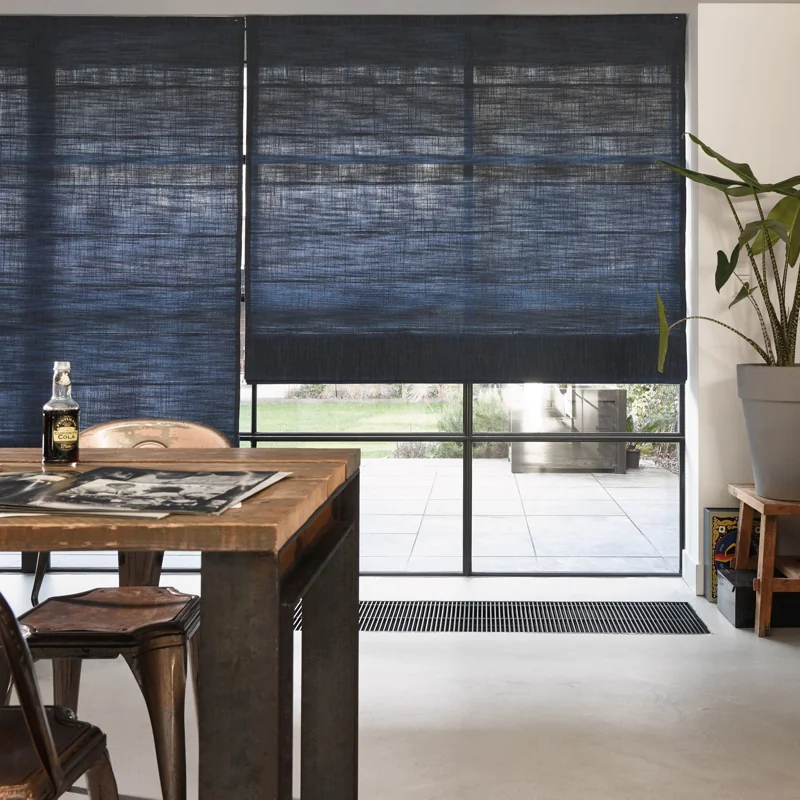 Blue textured Roman shades in a modern dining area