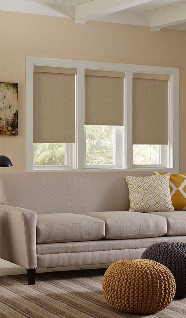 Beige roman blinds over a sofa with patterned cushions