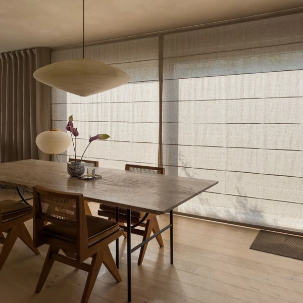 Linen roman blinds in a dining room with a stone table