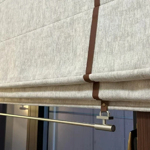Textured grey roman blinds with brown leather straps